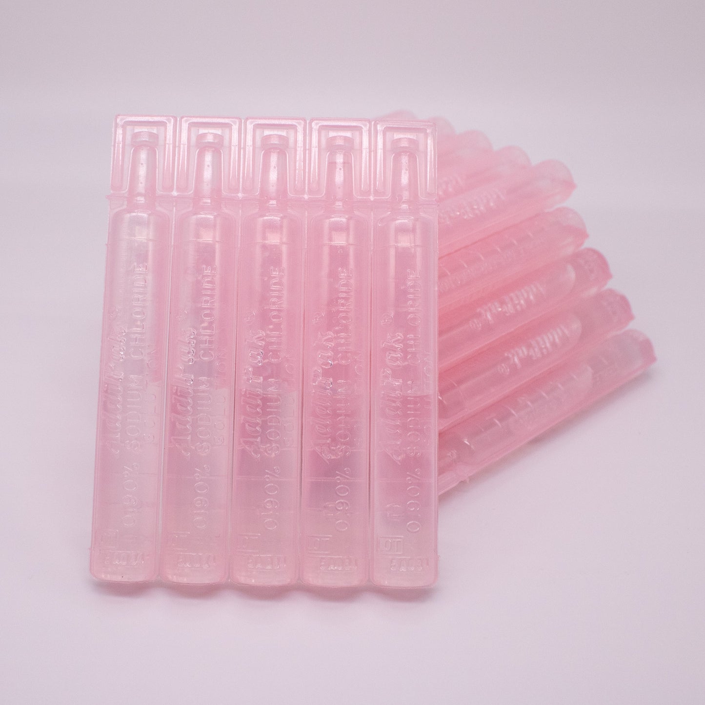 Stack of pink plastic straws on a light gray background