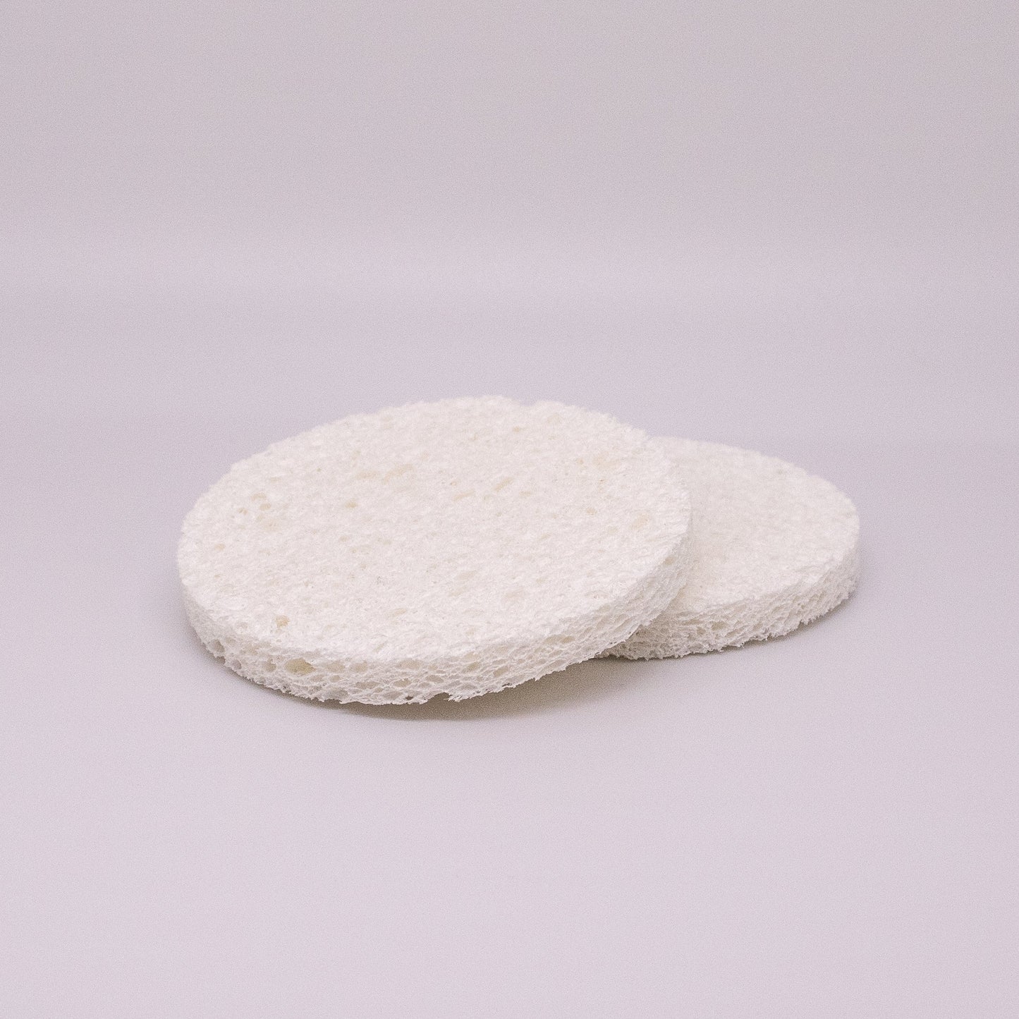 Two white circular pads on a light gray background