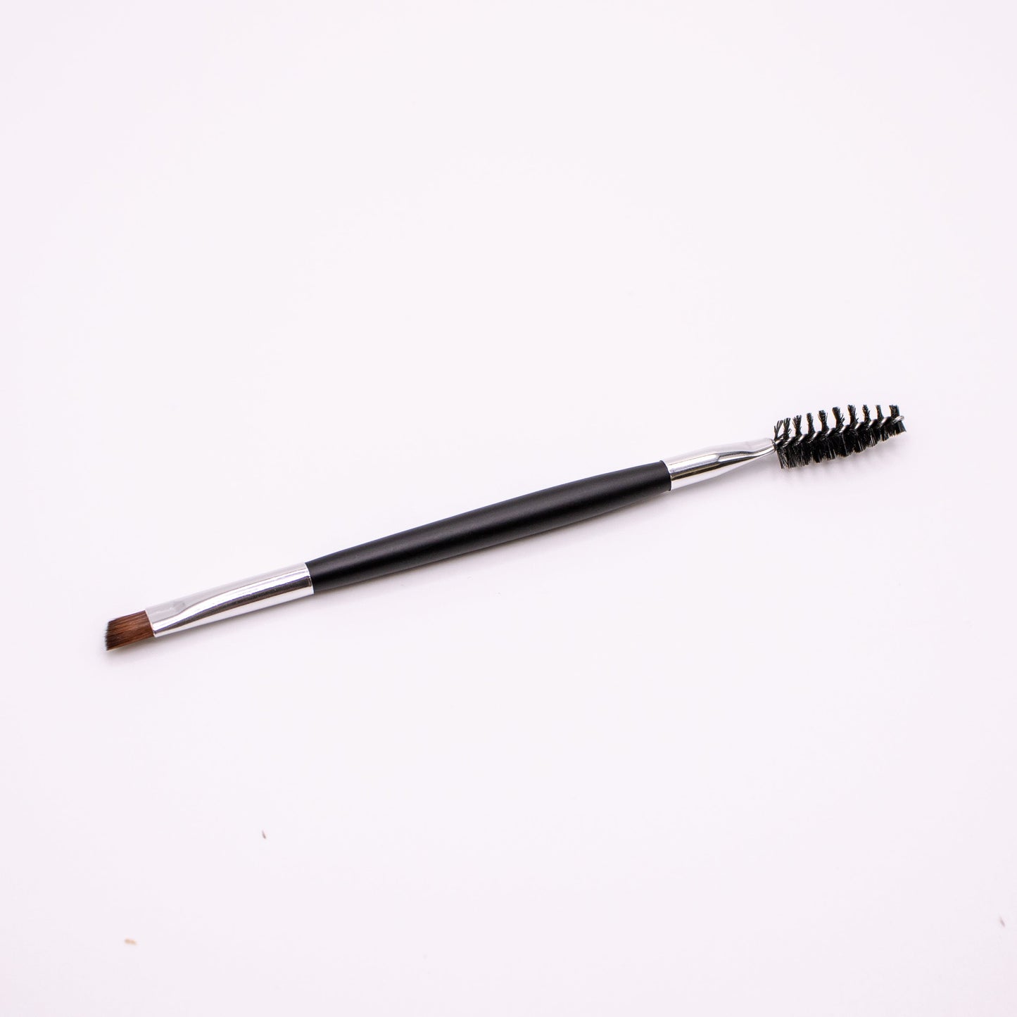Eyebrow brush with black handle and bristles on a white background