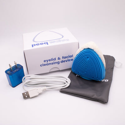 Eyelid and facial cleansing device with packaging, power adapter, USB cable, and pouch on a white background.