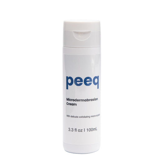 A bottle of Peeq Microdermabrasion Cream with white and blue labeling, indicating the brand and product details.